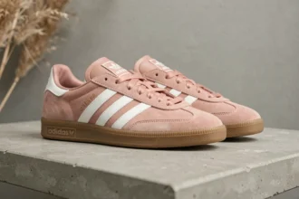 Paire de sneakers Adidas Samba Rose coloris rose poudré sur étagère en béton avec herbes de pampa séchées, finitions cuir blanc et semelle gomme